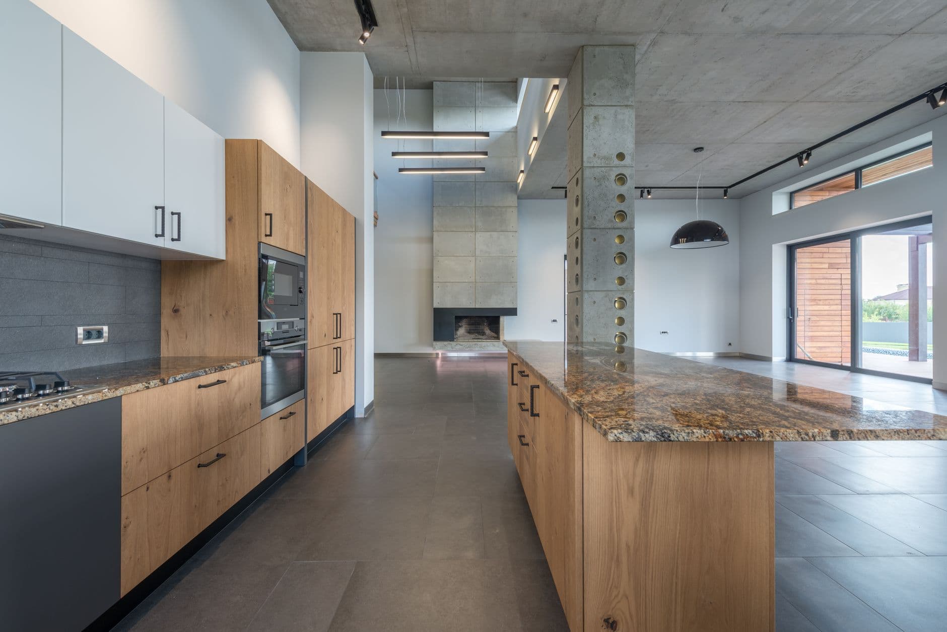 Light apartment kitchen with a substantial island, pale cabinetry and open circulation around it