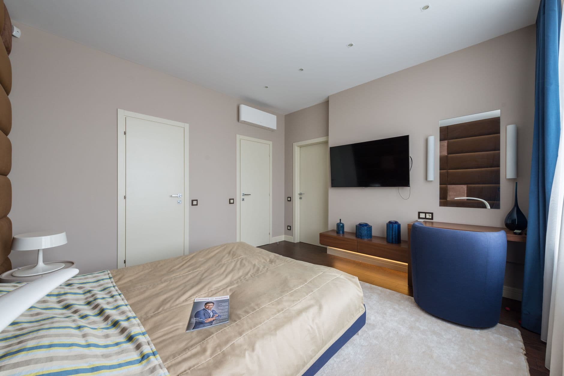 Pale contemporary bedroom with continuous mineral-toned walls, niches and soft curves