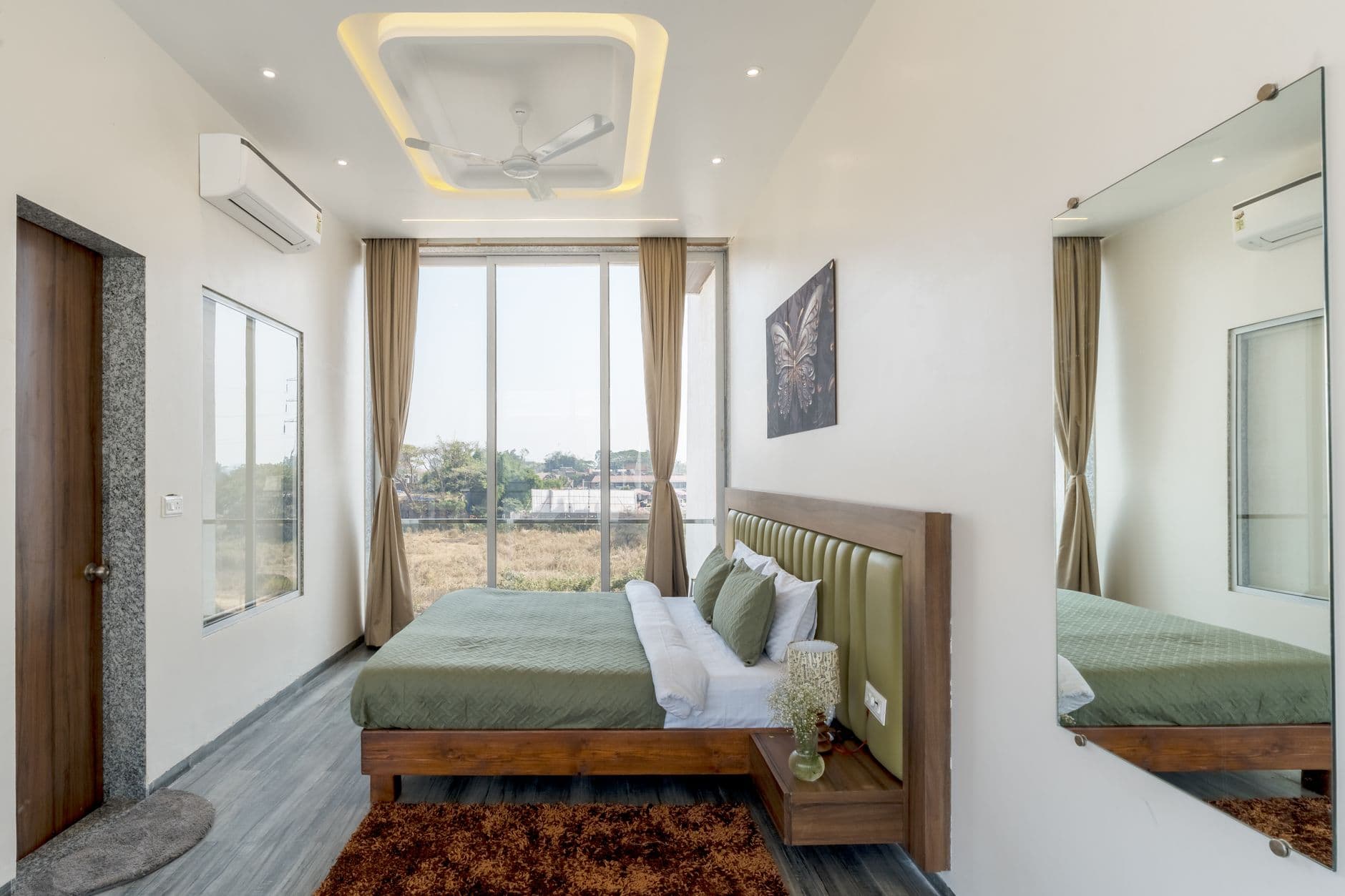 Modern bedroom with floor-to-ceiling glazing and a concealed ceiling blind recess