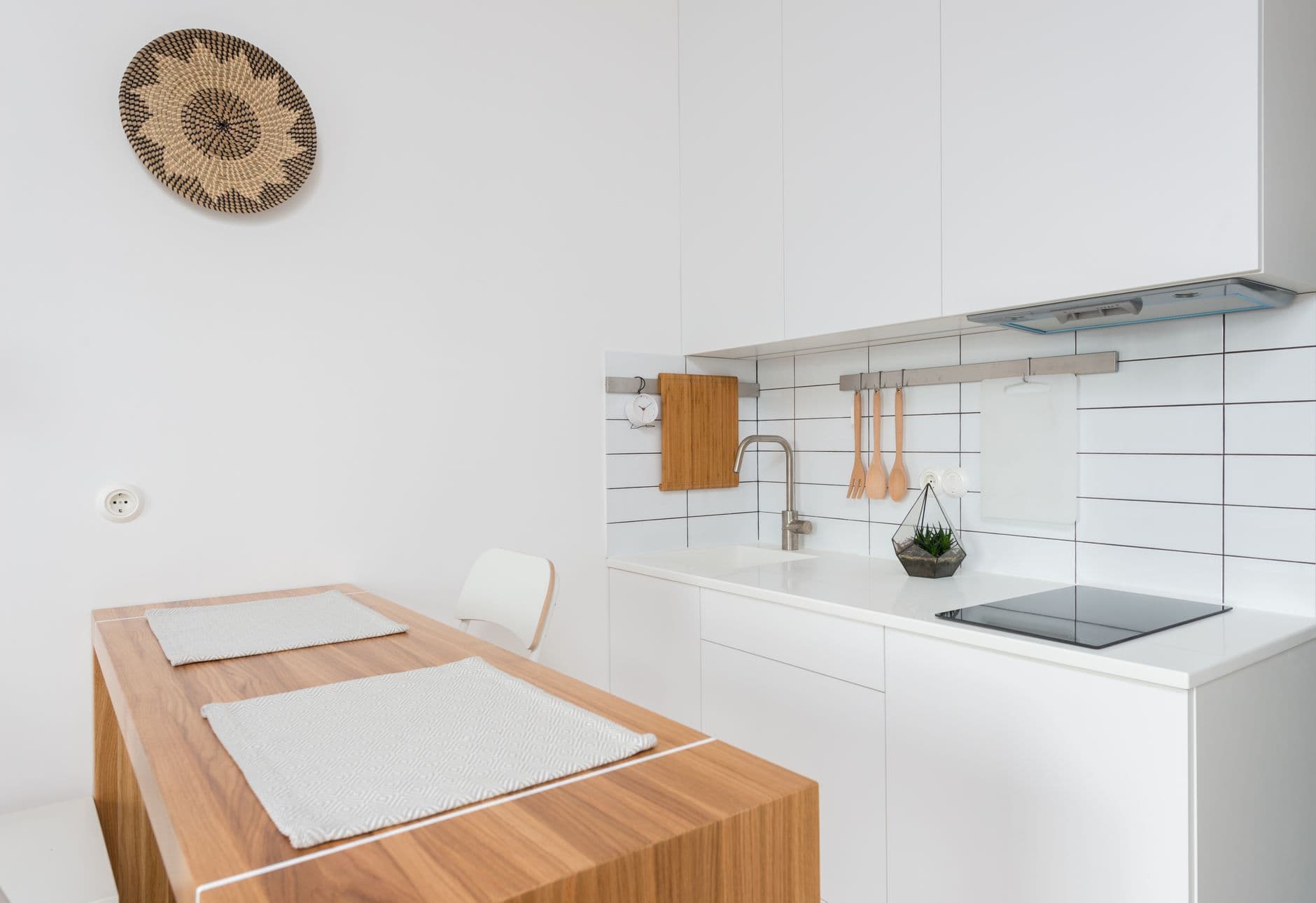 White and timber kitchen with oak cabinet fronts, pale worktops and a matte floor