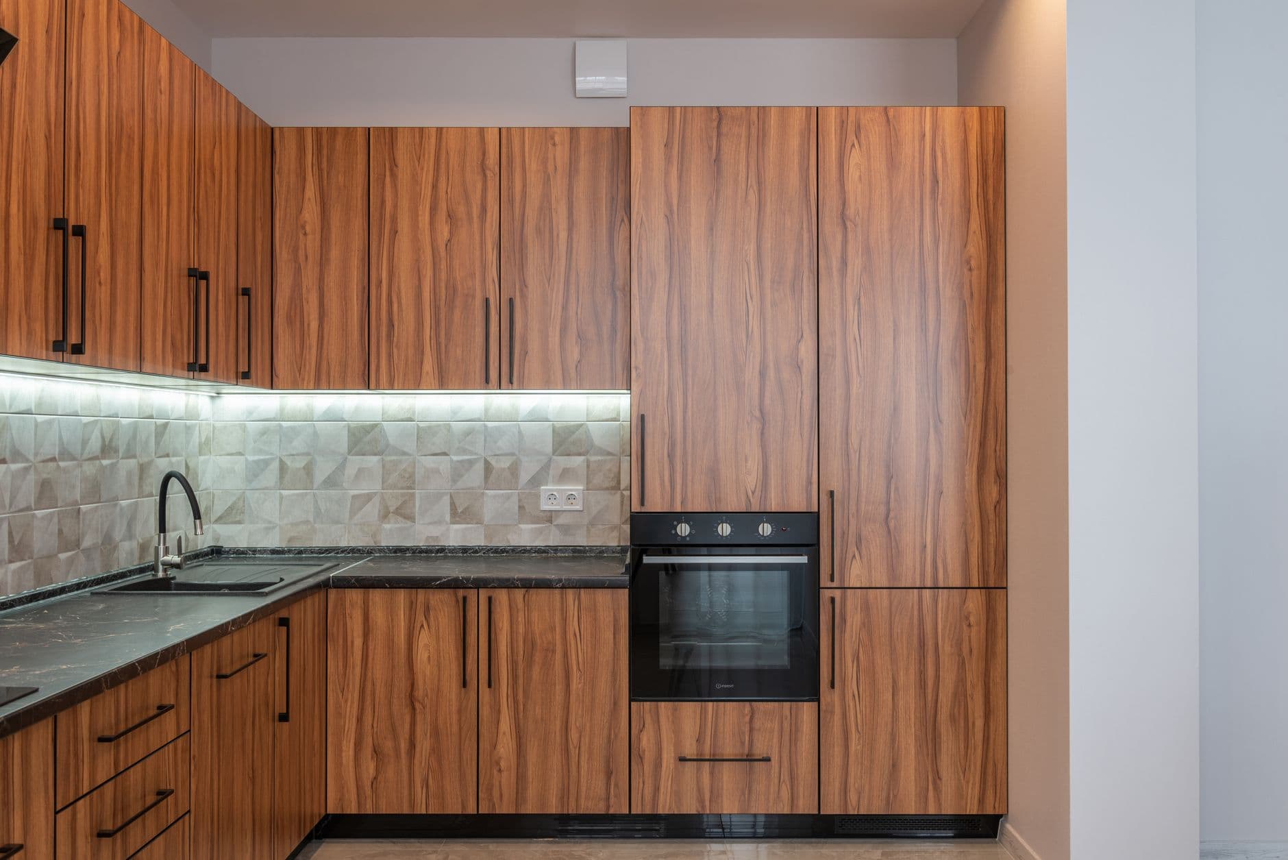 Spacious kitchen with a long counter, dining area and large windows overlooking greenery