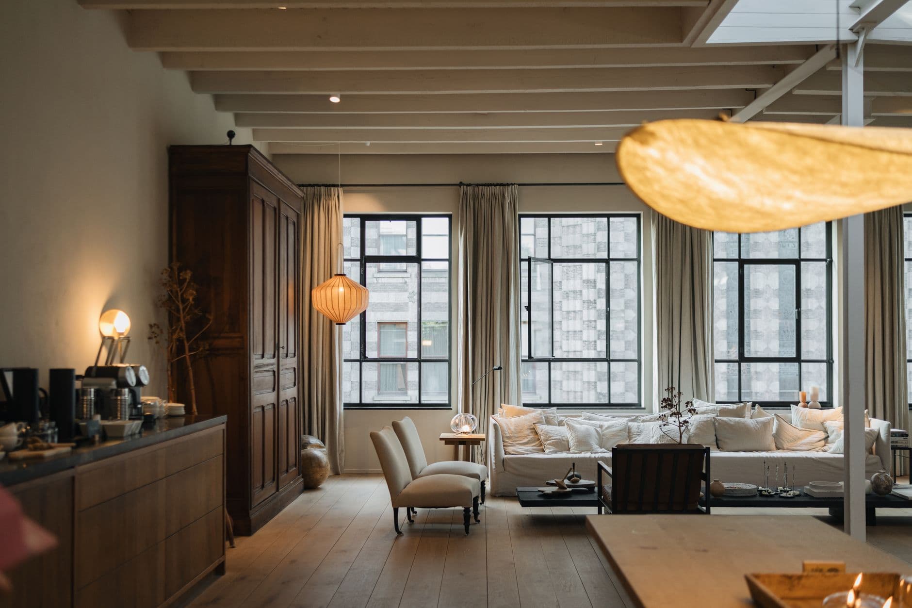 Living room with a rounded cream sofa positioned near large windows
