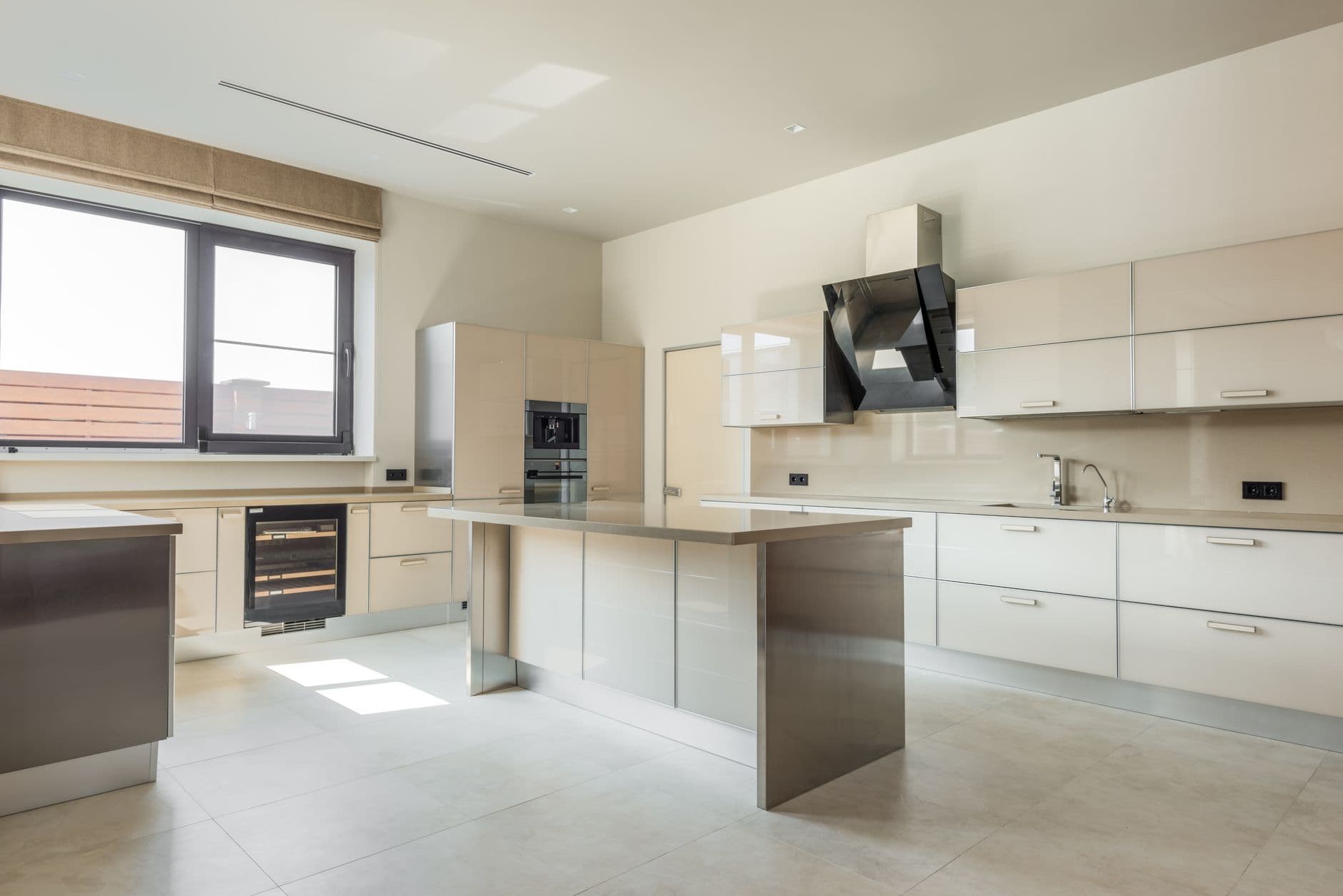 Minimal kitchen with a pale stone counter, oak cabinetry and daylight