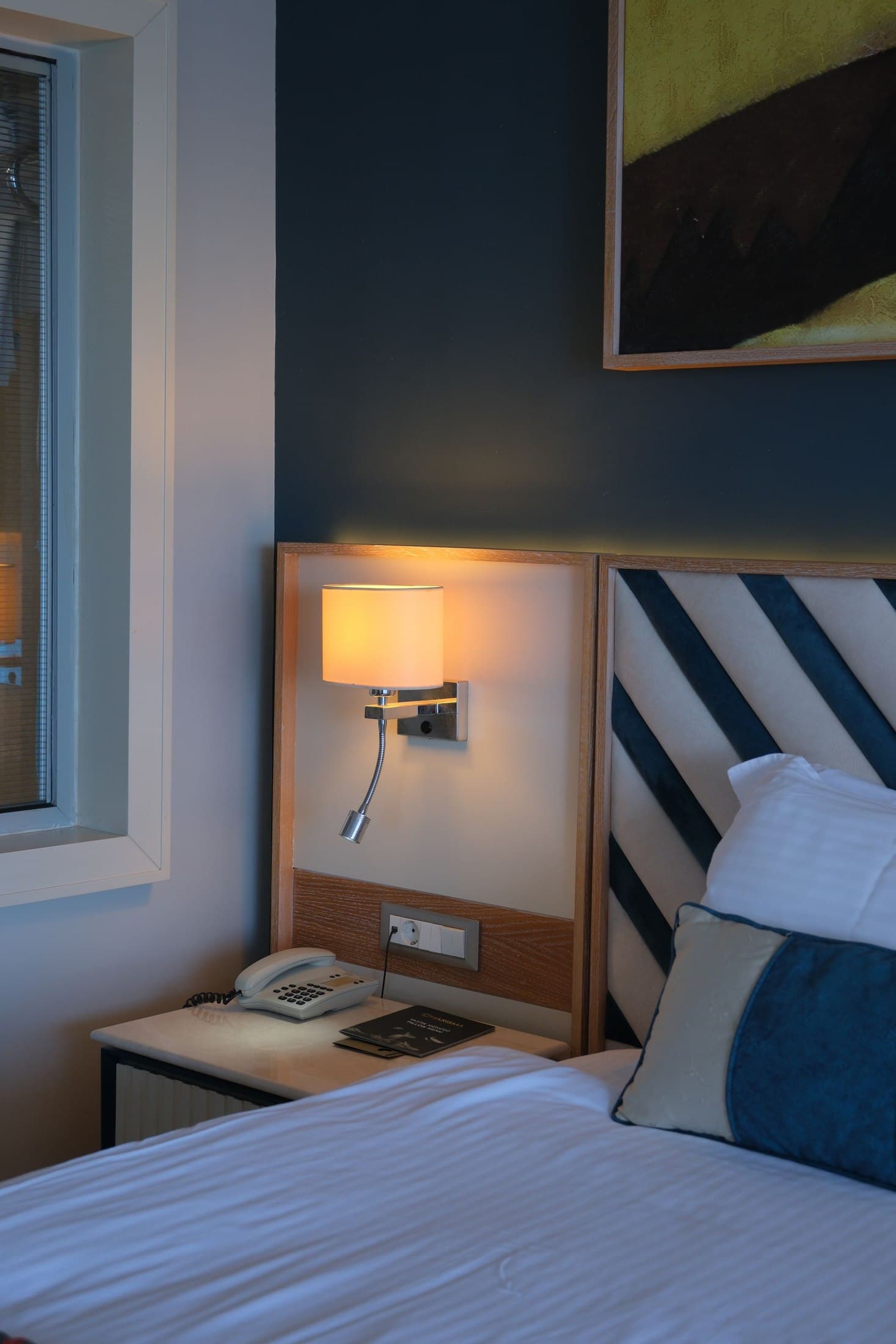 Hotel bedside table with wall-mounted reading light and controls