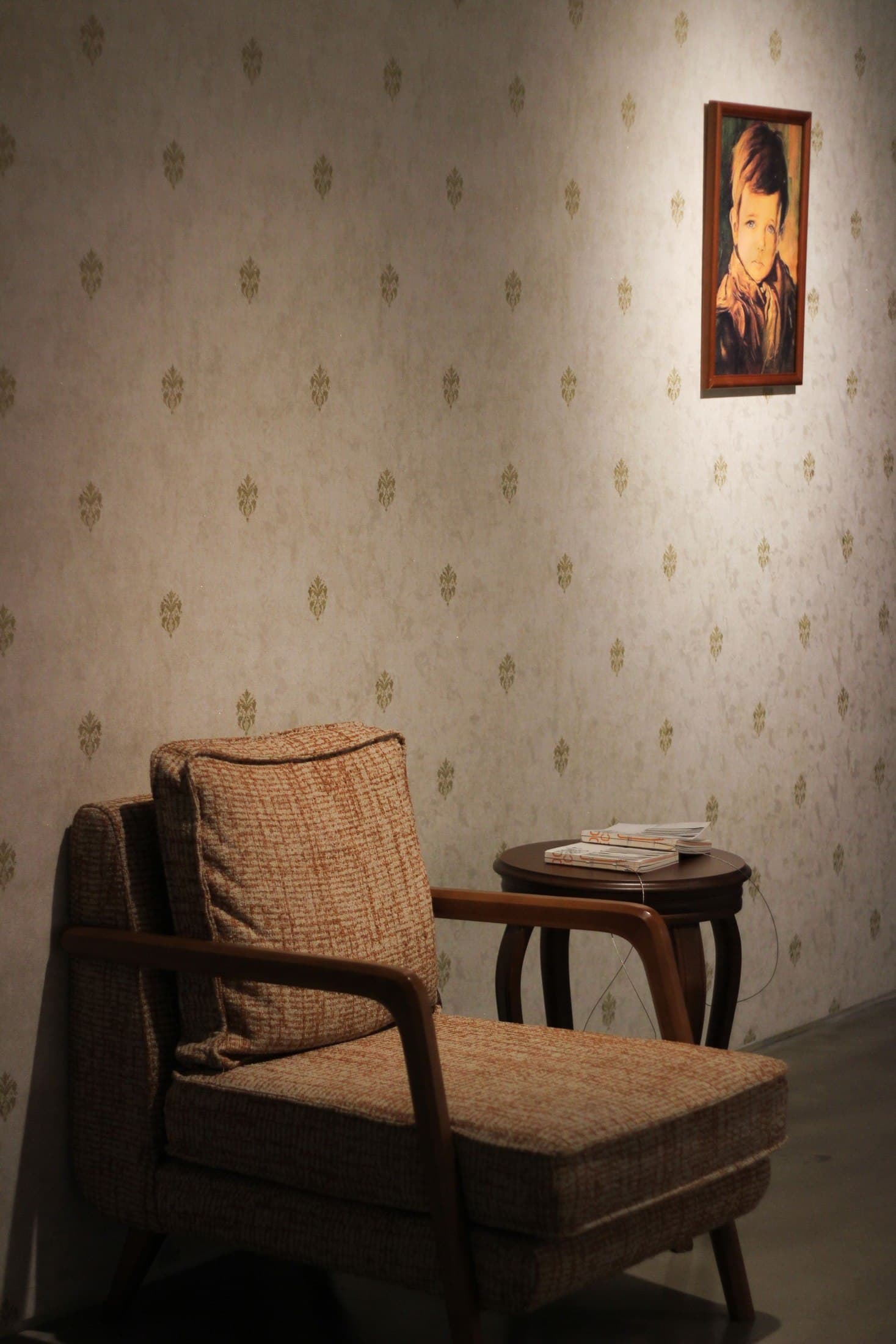 Aged upholstered armchair beside a small wooden table