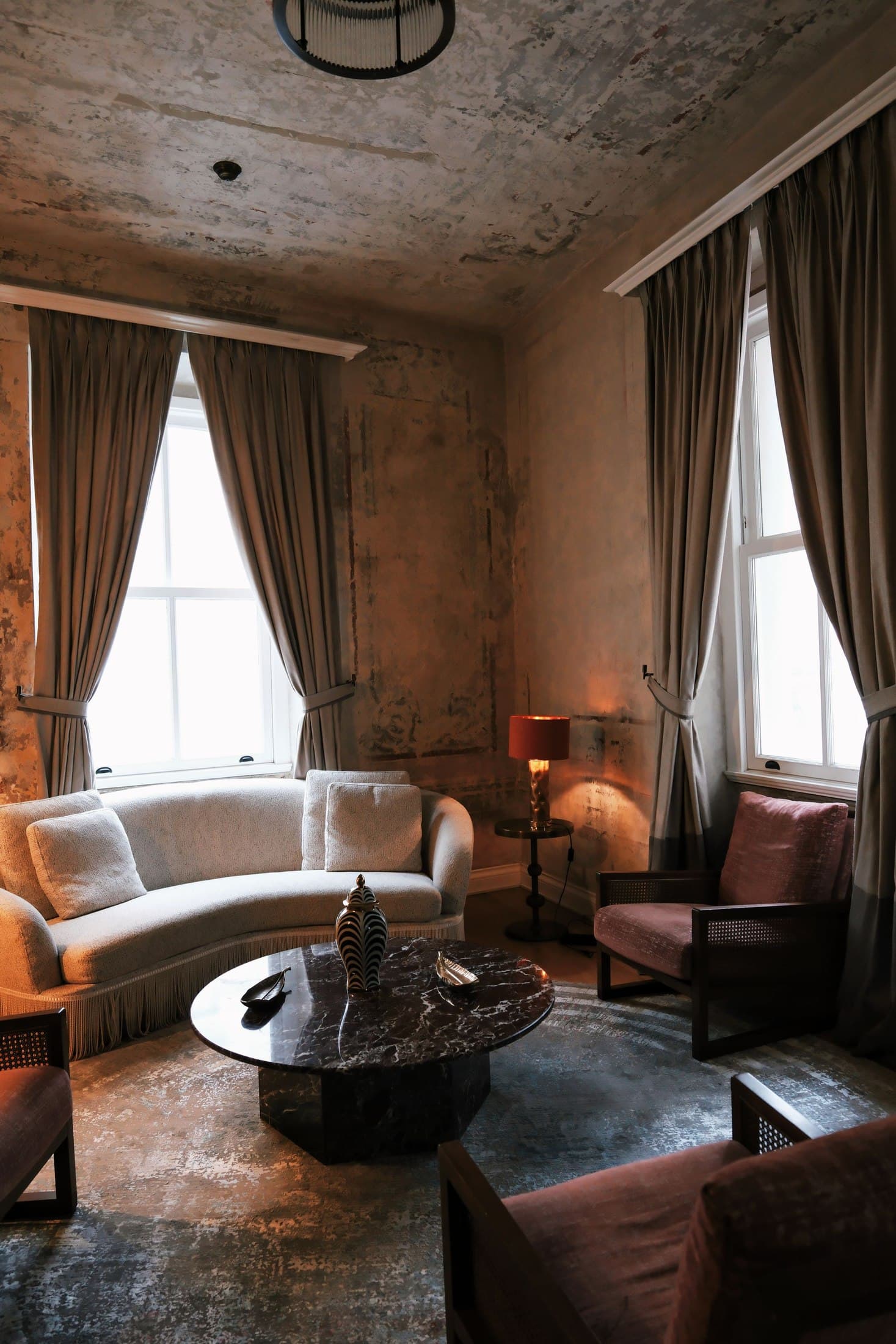 Vintage styled room with mixed seating and open floor around a low table