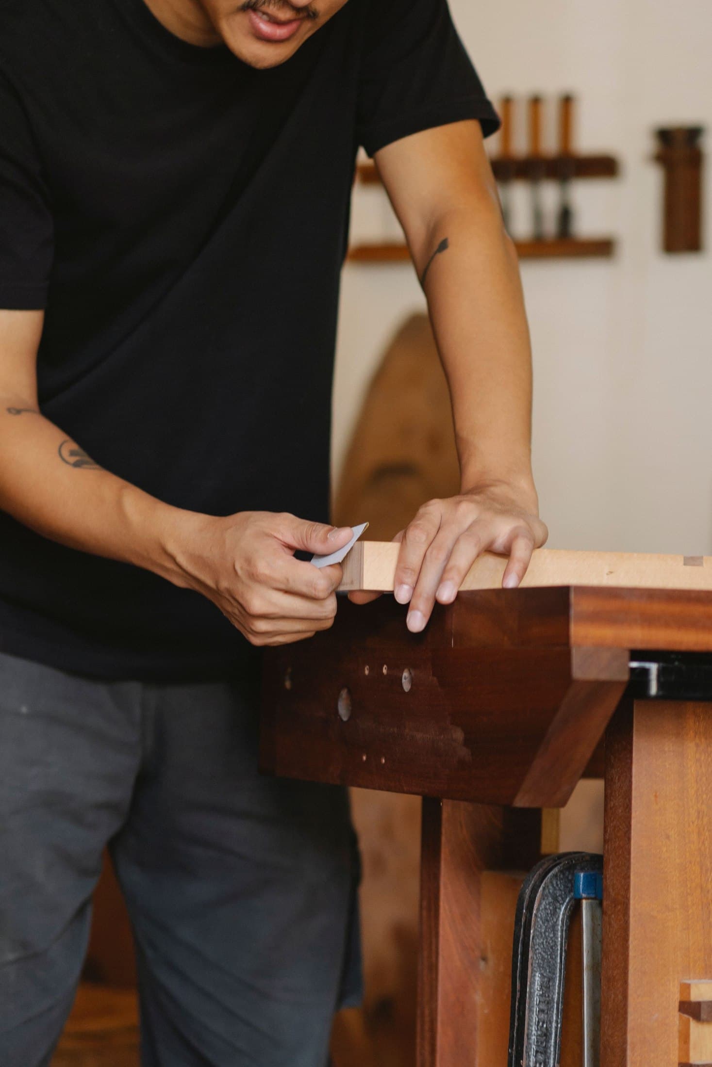 Furniture maker sanding a timber component at a workbench