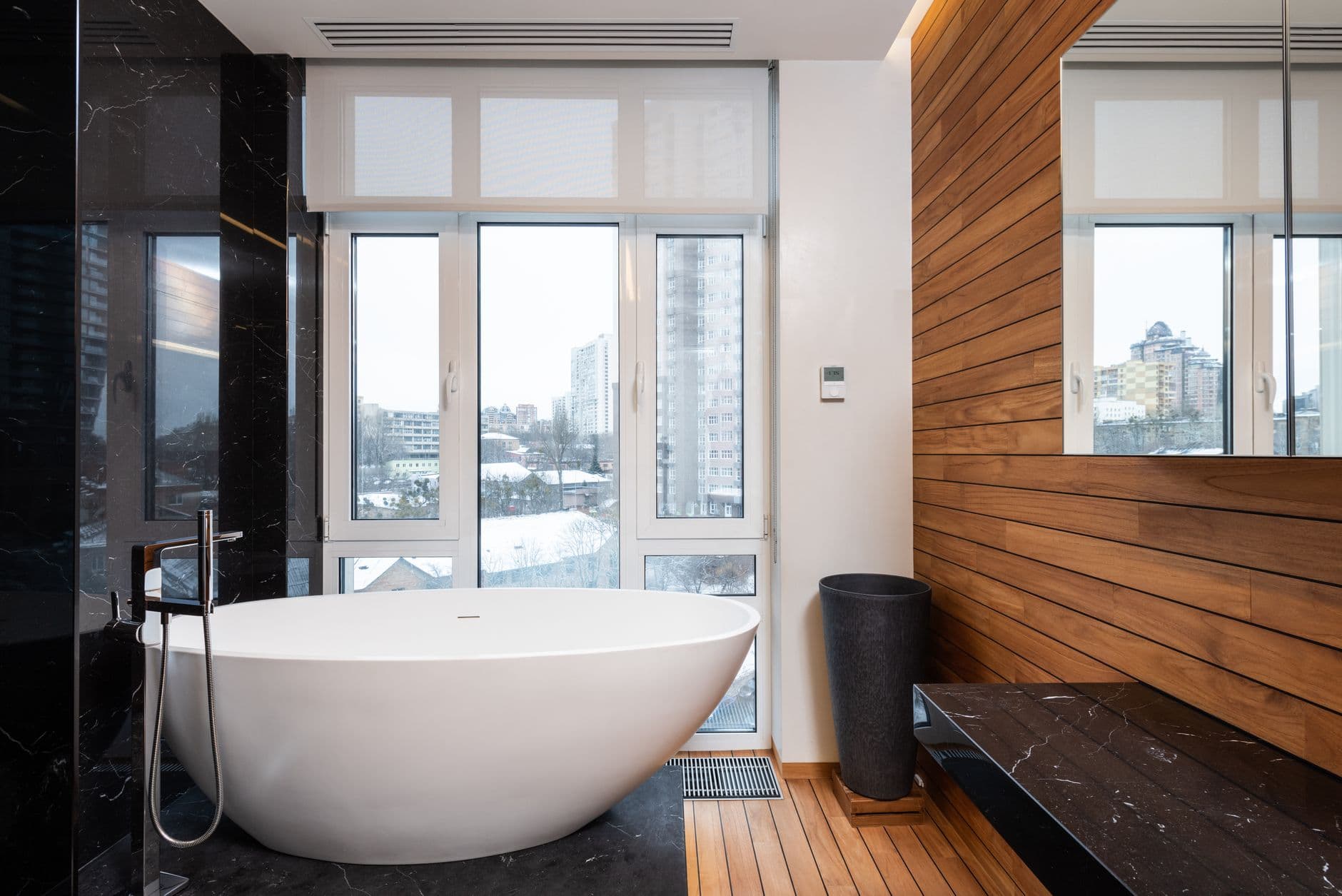 Modern bathroom with a freestanding bath beside a tall garden window