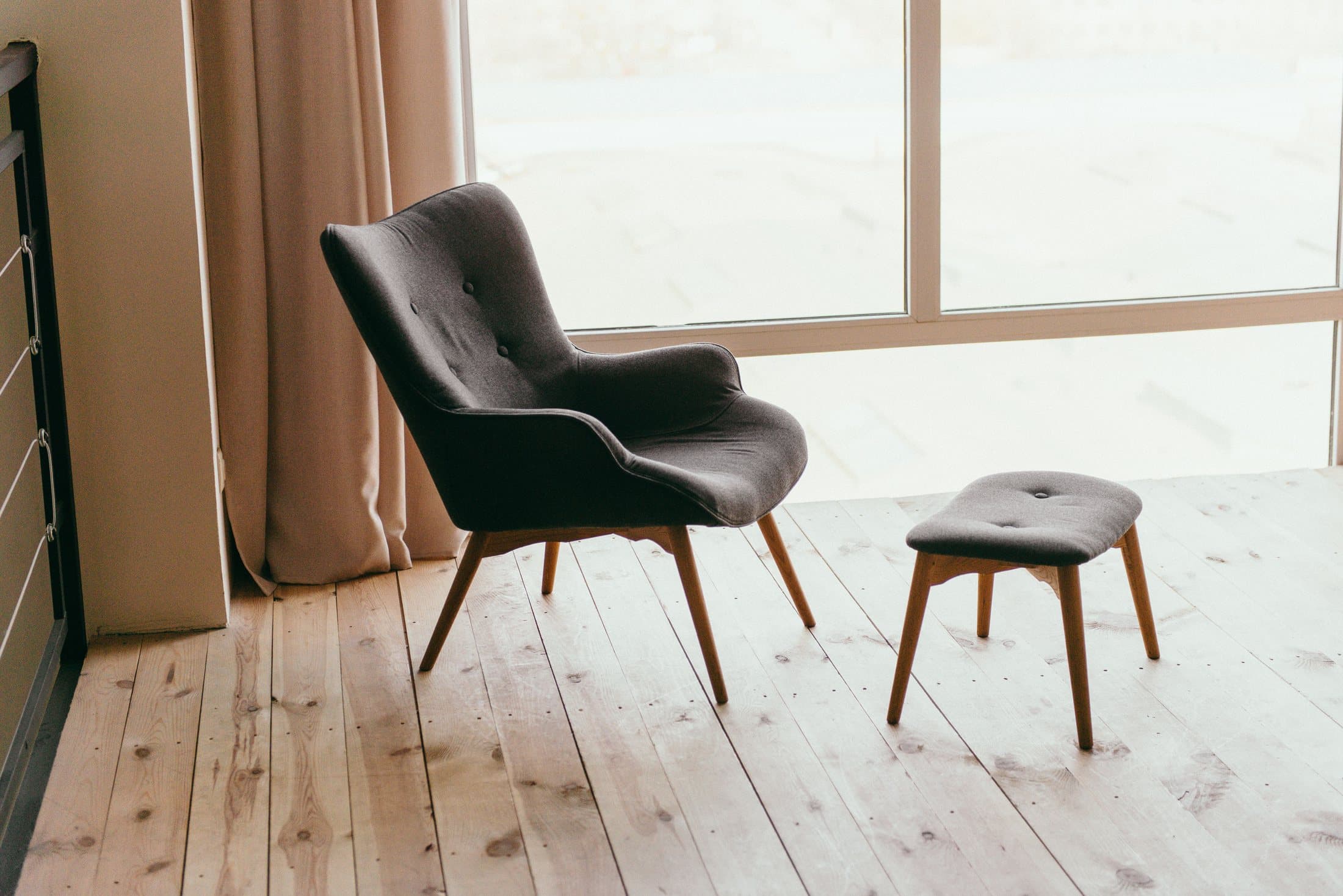 Contemporary armchair with a matching footstool in a sunlit room
